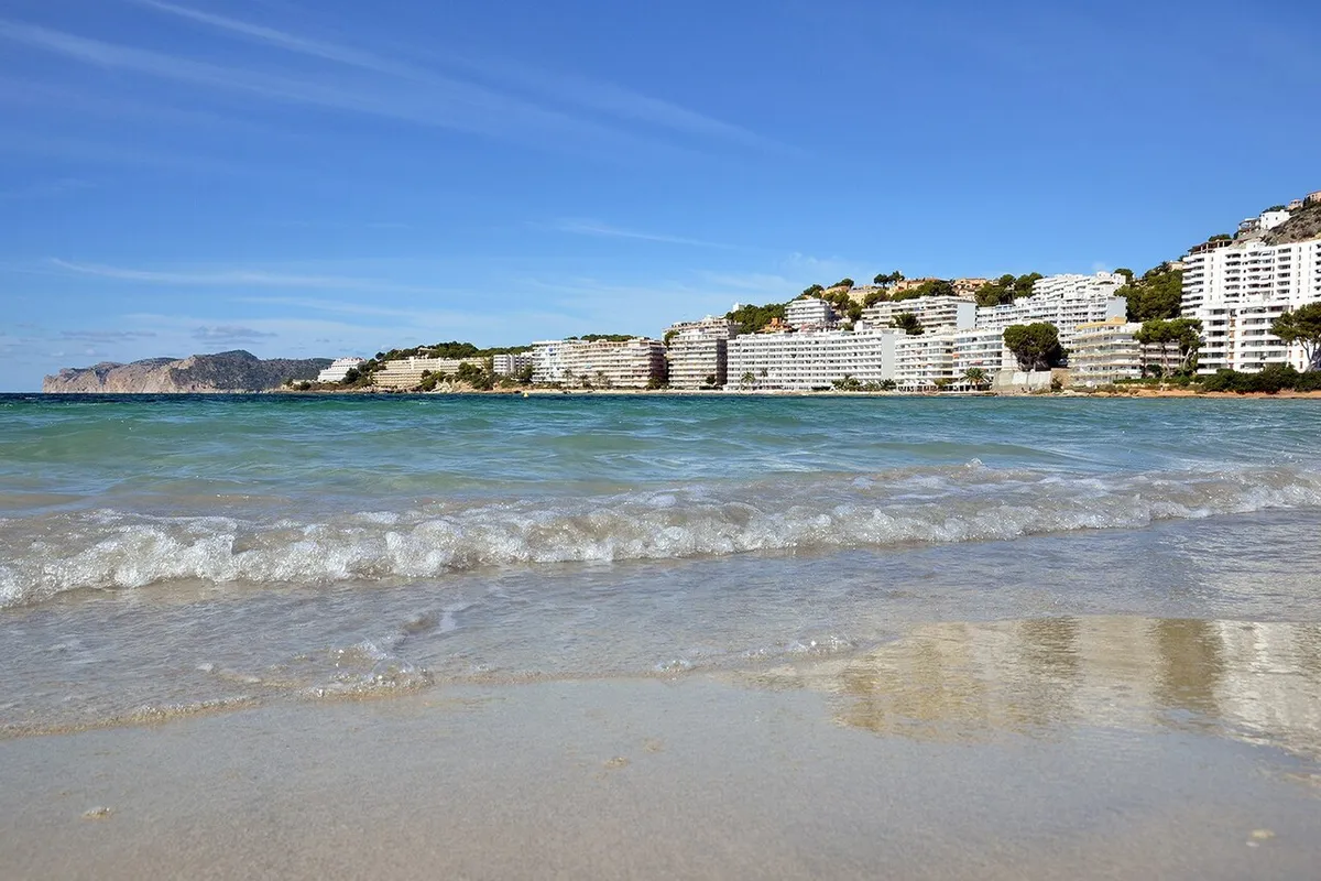 Sandstranden i Santa Ponsa med klart vann og hotellene rundt bukta